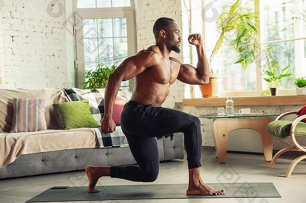 非裔美国人男人。教学首页在线课程健身有氧运动生活方式检疫活跃的孤立的健康运动概念培训仰卧起坐