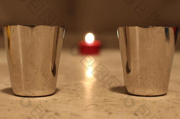 两个小金属杯之间的蜡烛