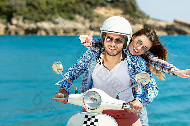 美丽的年轻情侣相爱，在美丽的自然环境中享受骑摩托车的乐趣
