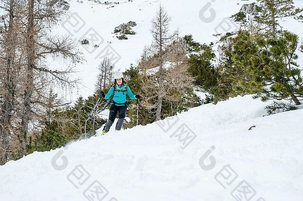 女滑雪者在山里享受乡间滑雪。