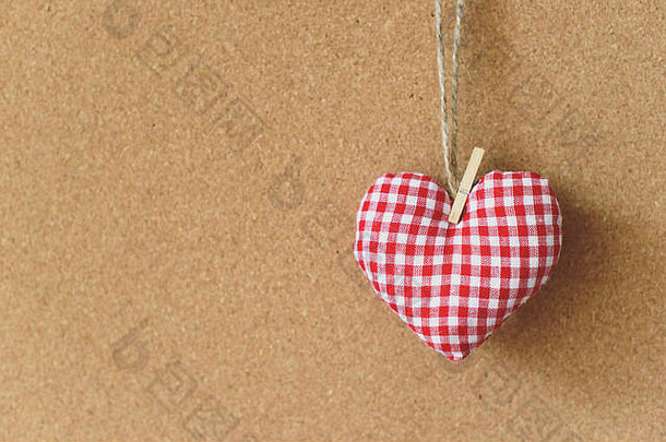 红色纺织心形，棕色工艺回收软木板背景。免费拷贝空间。情人节的概念。