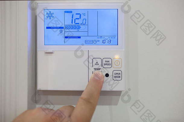 在家里用电子设备调节房间的气候控制。手指按压12摄氏度
