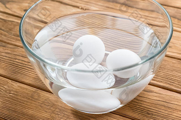生鸡蛋放在一碗水里。侧视图