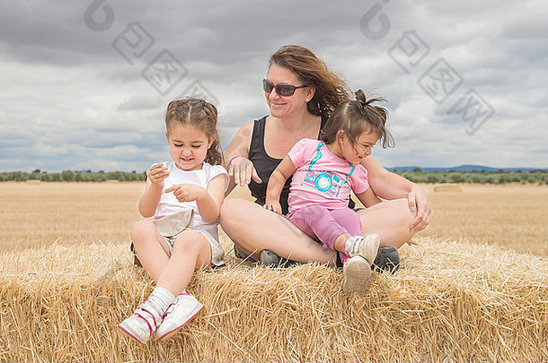 美丽的高加索人家庭玩稻草场