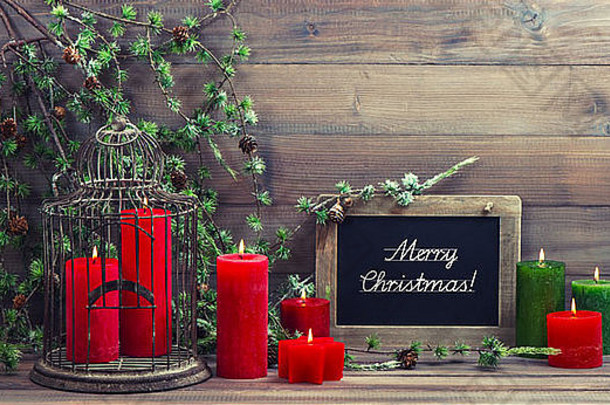 复古圣诞装饰鸟笼、红蜡烛和松枝。