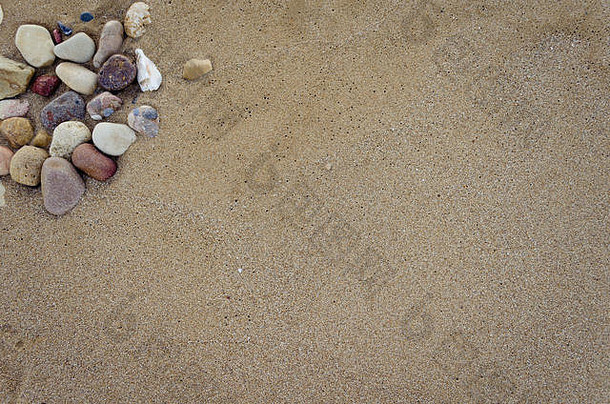 美丽的海滩沙滩背景和鹅卵石。褐色砂质结构，含石块。夏季概念。顶视图。空间。
