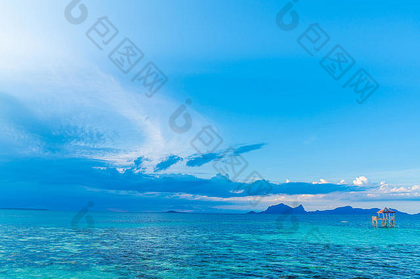 热带背景绿松石海蓝色的天空遥远的岛屿地平线小结构高跷中间海黑暗云迦特