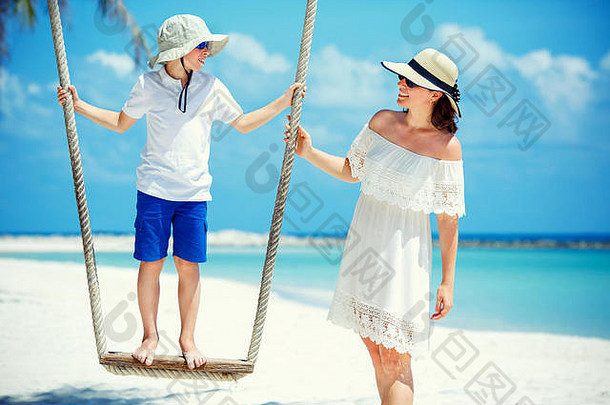 年轻的美丽的女人摆动儿子热带海滩KOHPhangan岛泰国