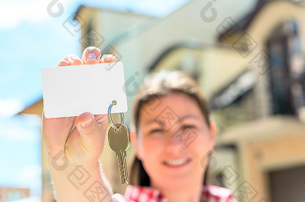 快乐女人手里拿着钥匙的卡片。关注重点