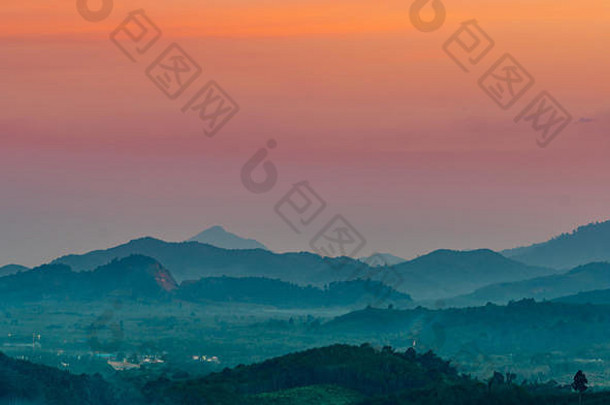 山峦自然风光秀丽，夕阳西下，云彩缭绕。泰国山谷中的一个乡村。都城的山景