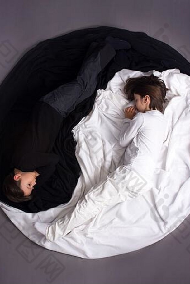 两个孩子，穿着黑白衣服，躺在阴阳圈的地板上，形影不离