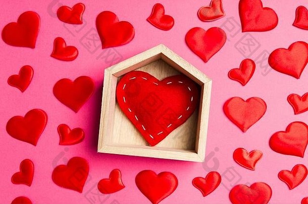 在彩色背景上装饰着小红心的木屋中，红色红心的特写镜头。情人节。家甜家的概念。