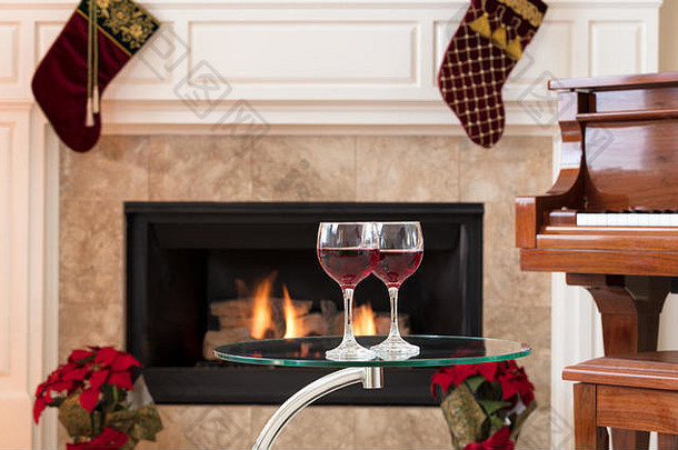 眼镜红色的酒前玻璃表格发光的壁炉计划假期装饰背景