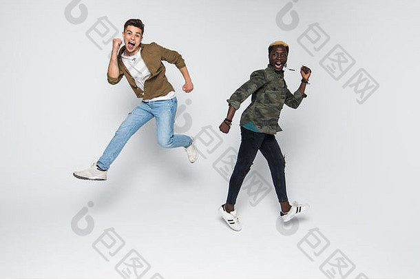 两名混血青年在白色背景上跳跃和庆祝的肖像