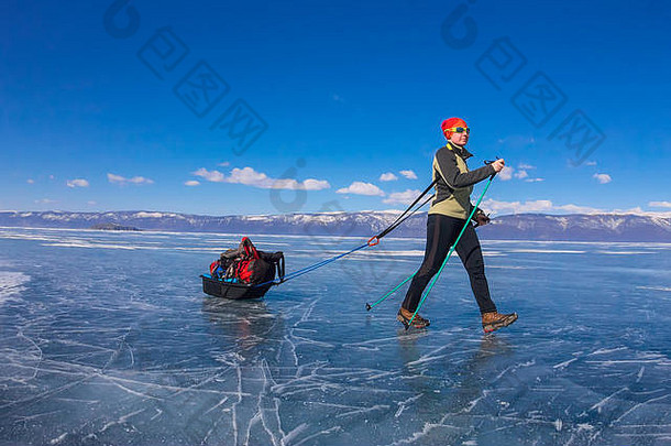 带着雪橇和<strong>登山杖</strong>的女孩在贝加尔湖的冰面上。