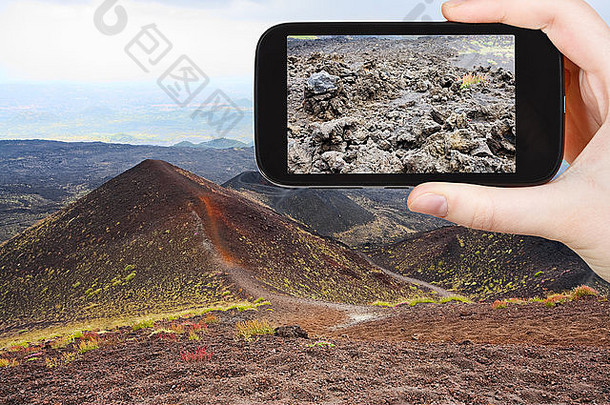 旅游理念-意大利西西里岛，游客在手机上拍摄埃特纳火山口照片