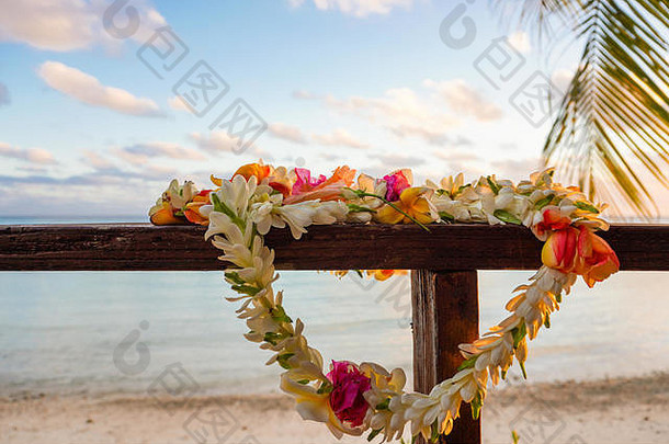 在南太平洋法属波利尼西亚的一个环礁湖上，一束美丽的花停在木制甲板的栏杆上