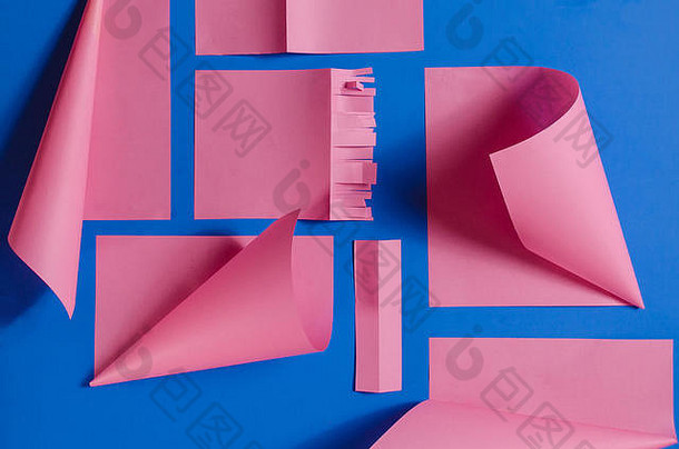 粉色剪纸在孤立的蓝色背景上，立体效果突出。