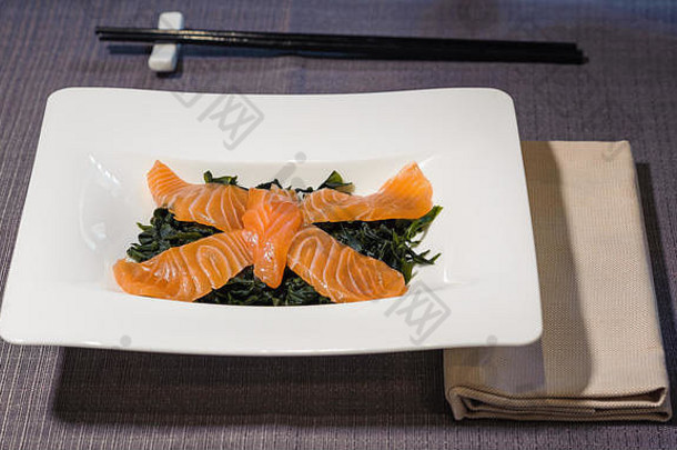 大马哈鱼鱼片床上藻类经验丰富的大米醋服务矩形白色板黑色的筷子