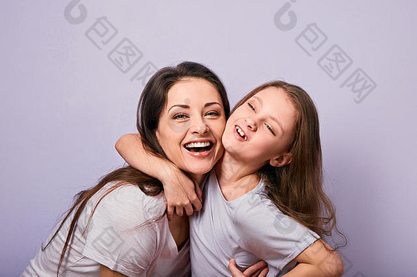快乐妈妈。兴奋欢乐孩子女孩拥抱情感微笑脸紫色的背景空复制空间特写镜头