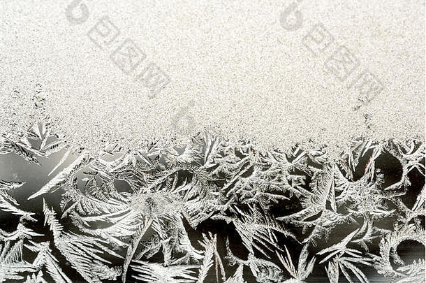严寒的冬天，透明的玻璃窗上结满了霜和冰，形成了冰的形状和图案。