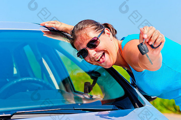 快乐的女人展示她的新车钥匙