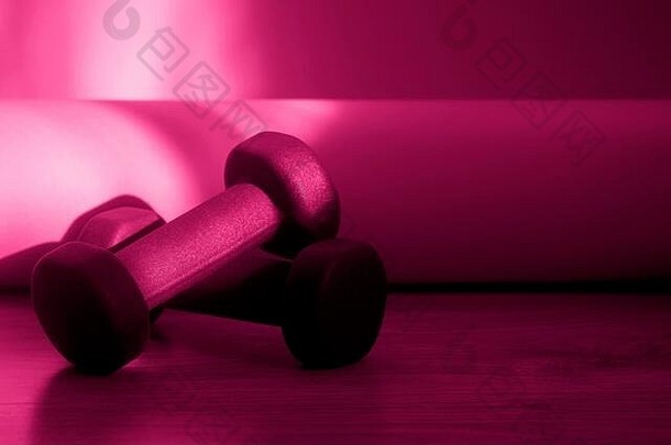 健康背景健身器材，木地板哑铃。健康的生活方式，运动理念。粉红色滤光片
