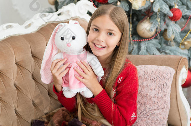 太可爱了。小孩玩软<strong>玩具</strong>。小孩带着礼物开心地笑着。最好的圣诞<strong>玩具</strong>。小女孩和可爱的兔子在圣诞树旁。小女孩抱着兔子<strong>玩具</strong>。