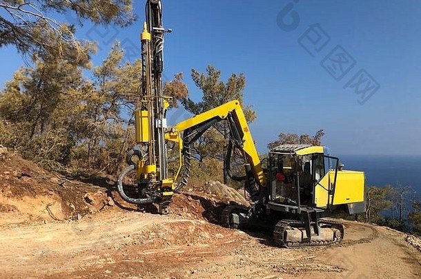 黄色<strong>机械公司</strong>在进行爆破钻孔作业时，正在岩石海崖顶部钻孔。土方、挖掘、岩石上的挖掘