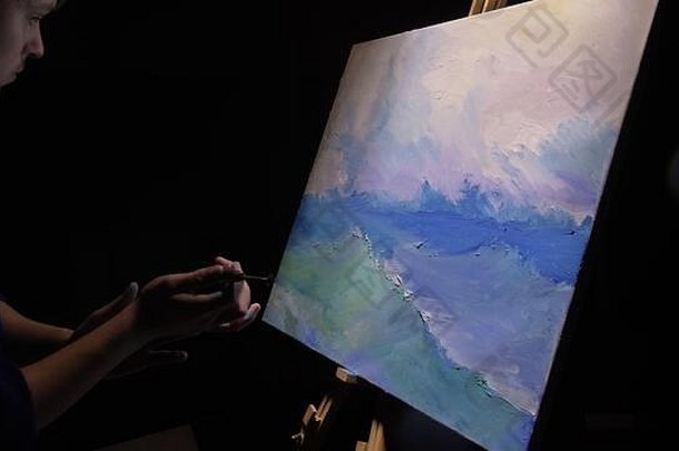 艺术家模仿者用海洋中的船描绘海景。工匠-装饰师用丙烯酸油彩绘制蓝色海洋上的船帆。