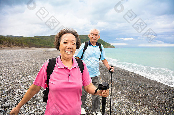 快乐的老年夫妇在海边徒步旅行