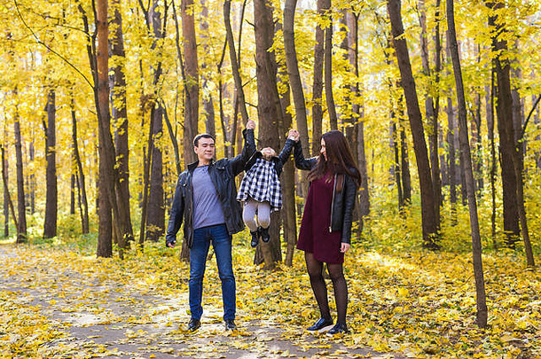 人、家庭和休闲理念——混血父亲和母亲与女儿在秋季公园玩得很开心