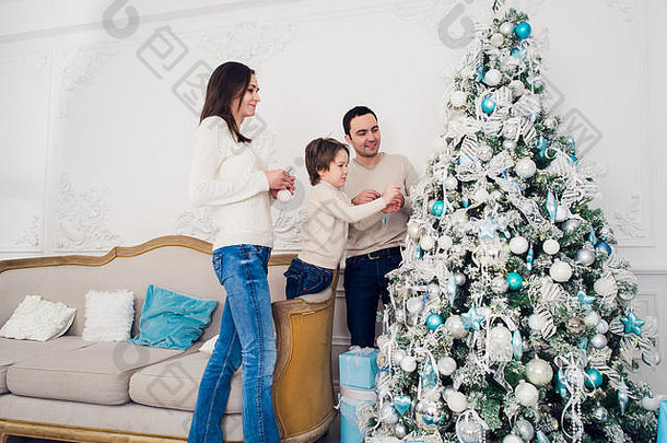 一家人在客厅用花束装饰圣诞树