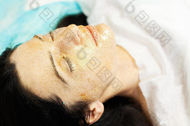 水疗中心治疗年轻的女人面部面具美沙龙