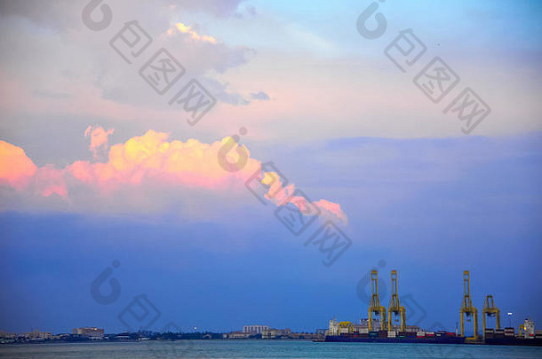 从槟榔屿海峡到马来西亚巴特沃斯集装箱港。热带日落背景，粉红色云层衬托下的<strong>黄鹤</strong>