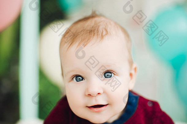 甜蜜的婴儿男孩大蓝色的眼睛说谎肚子微笑