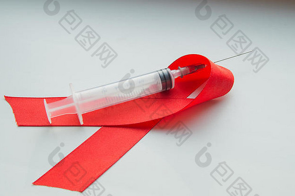 白色背景上的红丝带和注射器：<strong>世界防治</strong>艾滋病<strong>日</strong>，12月宣传公众对艾滋病毒感染者健康的支持