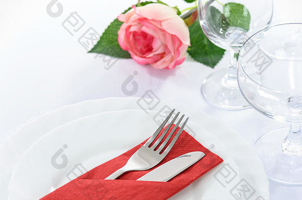 优雅的餐厅表格设置浪漫的晚餐玫瑰盘子餐具高脚杯子