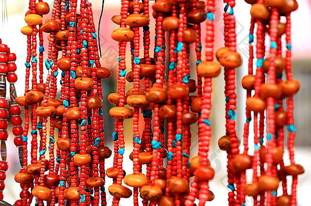 日喀则市县市场上的一个小摊上出售的红色石珠项链。中华人民共和国——中国。