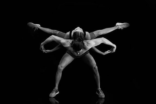 运动瑜伽情侣。一起跳舞。它们相辅相成。在健身房进行<strong>双</strong>人训练。健康的生活方式。显示出良好的体形。与健身有关。男人和女人在黑色的<strong>舞台</strong>上跳舞。