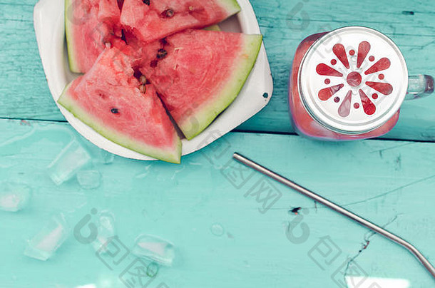 西瓜喝玻璃梅森Jar片西瓜冰蓝色的背景夏天新鲜的水果味注入排毒水前视图