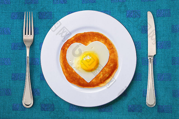 用刀叉在白色盘子上用炒鸡蛋做成的节日小吃