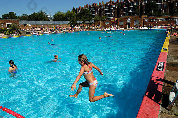 英国，伦敦，汉普斯特德，在丽都户外游<strong>泳池</strong>跳入水中的年轻女孩