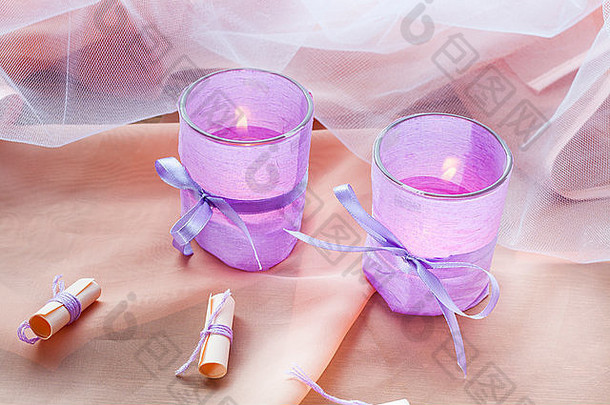 两支芳香的蜡烛放在玻璃烛台上，桌上贴着薰衣草纸