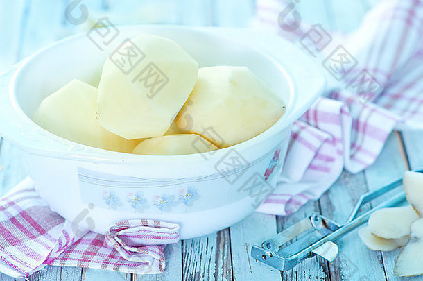 生土豆放在碗里和桌子上