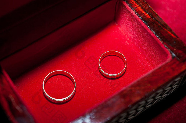 一对镶在木箱中红色天鹅绒垫子上的金色结婚戒指