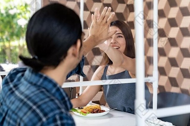 亚洲年轻的夫妇吃正常的社会距离餐厅表格掩护分区减少感染冠状病毒科维德