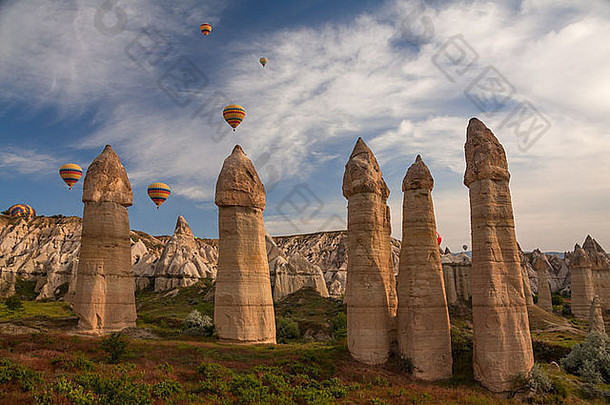 热气球飞越土耳其卡帕多西亚的岩石景观。