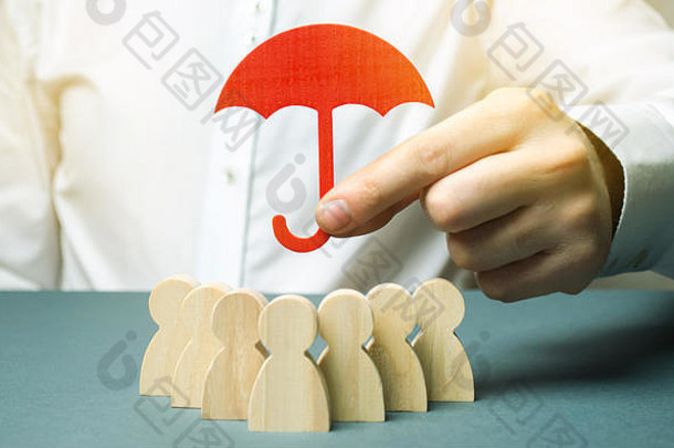 老板拿着一把红色的雨伞，用保护的姿态为他的团队辩护。人寿保险。客户关怀，员工关怀。安全保障