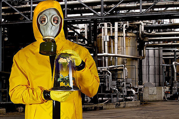 在化工厂的移动式温室里，一名穿着化工服、戴着面具的男子。